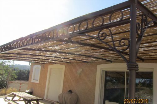 pergola fer forgé en pente grande terrasse décor poutre cercles livrée à Bages dans l’Aude